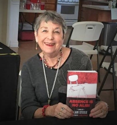 Lani Steele holding a copy of her book Absence Is No Alibi